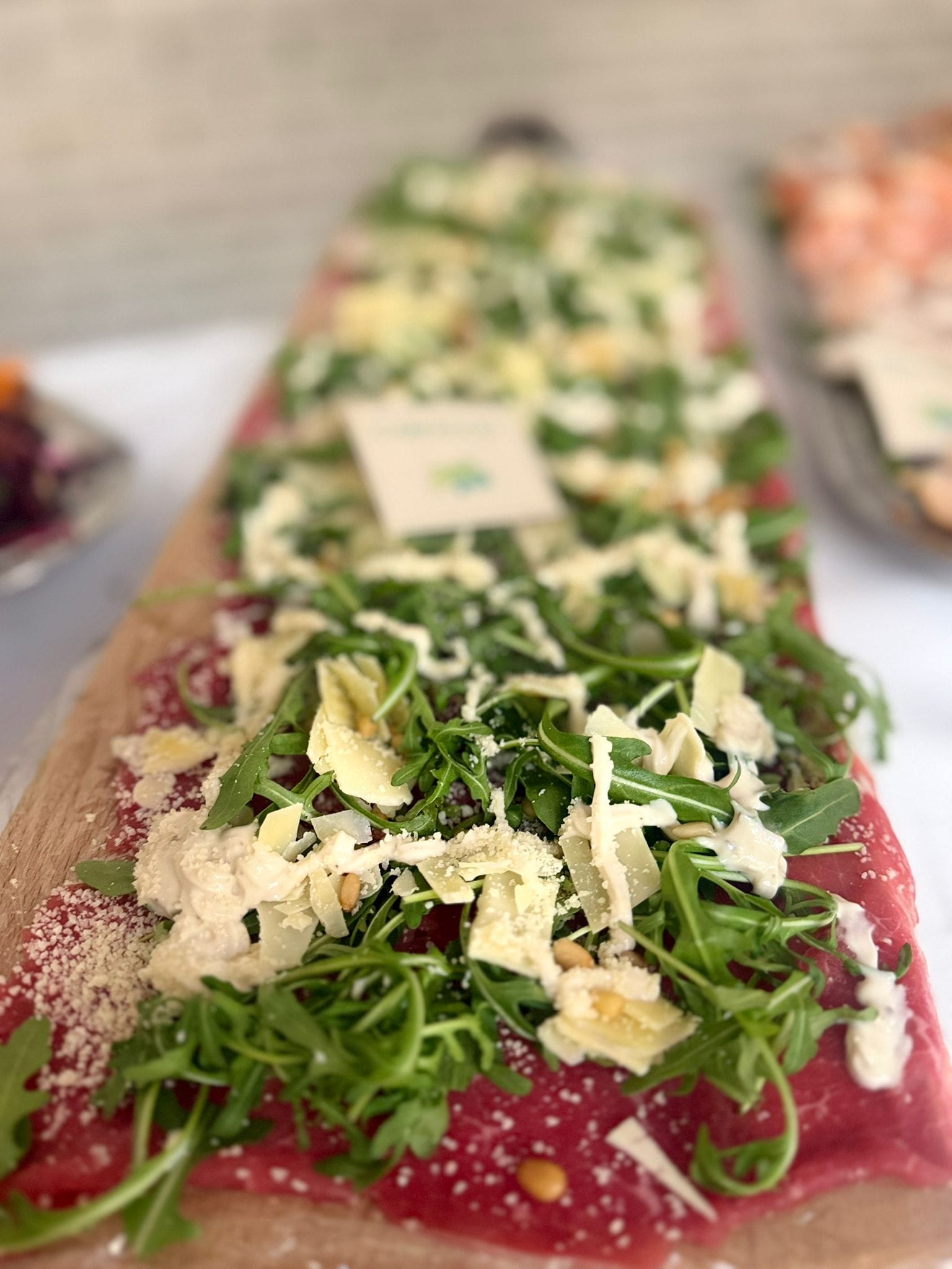 Lange plank met carpaccio, rucola, Parmezaanse kaas en pijnboompitten