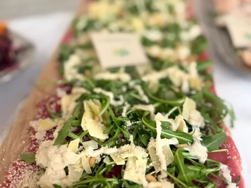 Lange plank met carpaccio, rucola, Parmezaanse kaas en pijnboompitten